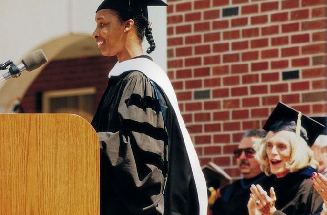 Loretta in academic regalia at the podium, accepting an honorary doctorate from Quinnipiac University