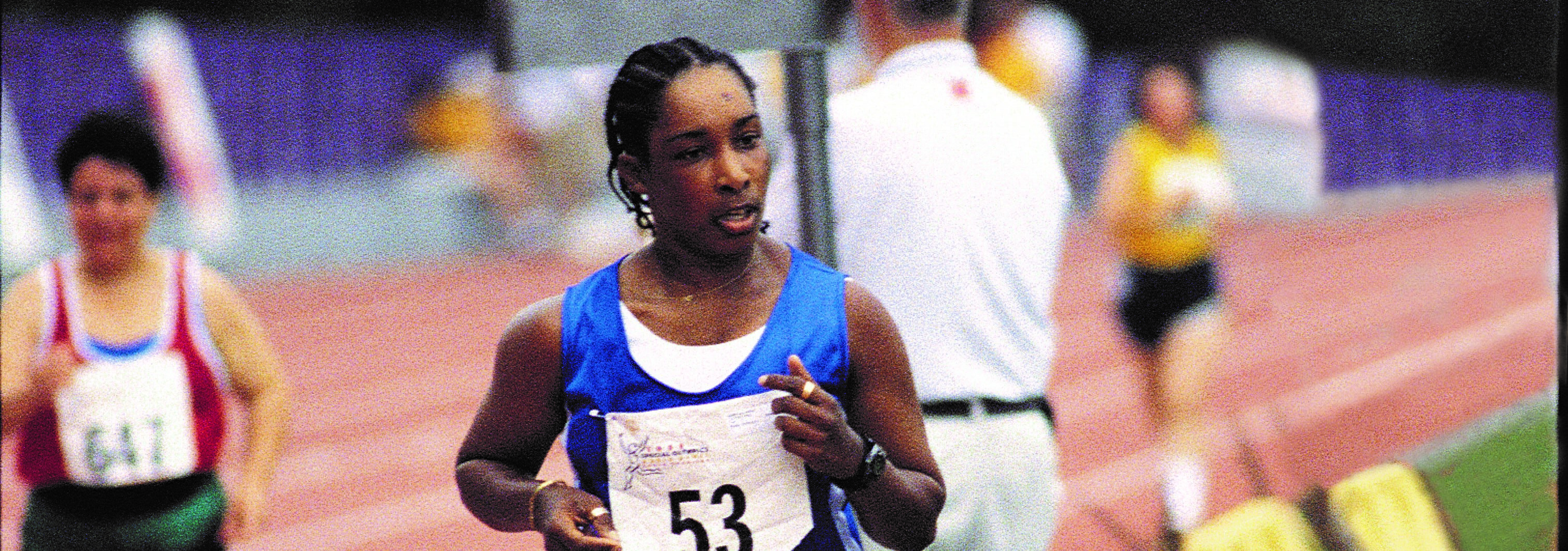 Loretta running a track race wearing bib number 53