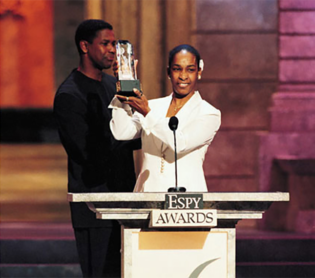 Loretta holding up the Arthur Ashe Award for Courage on stage at the ESPY Awards