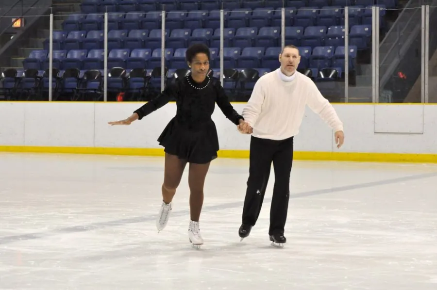 Loretta and David skating hand in hand on an ice rink