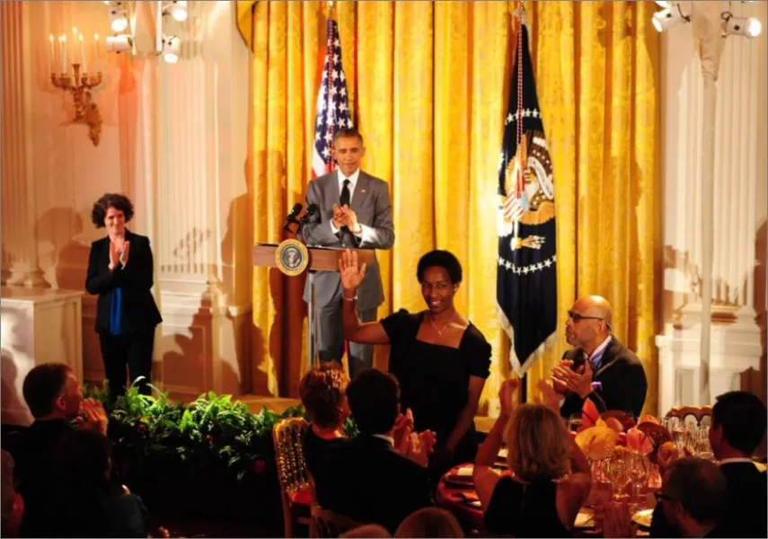 President Barack Obama recognizing Loretta, who stands with a raised hand, at a White House event